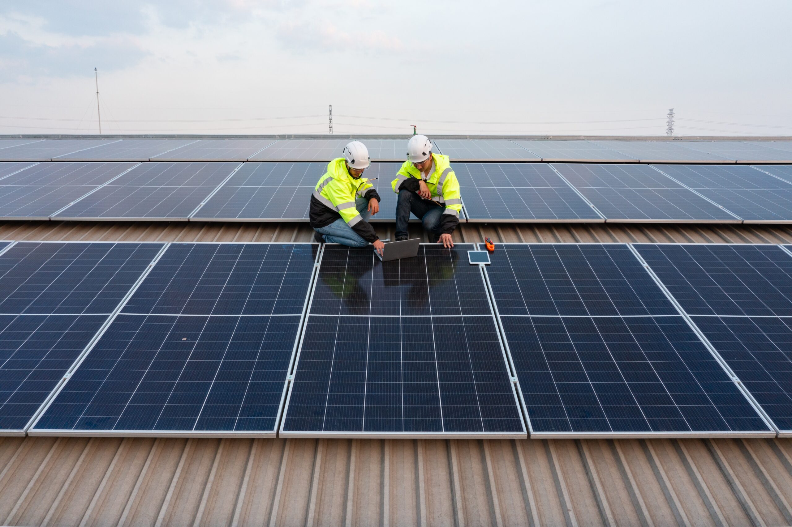 Drone,View,Of,Technician,Installing,Solar,Panels.,On,The,Factory